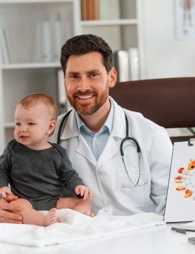 sitting-and-smiling-doctor-with-little-baby-is-wo-2025-03-18-21-04-12-YZR9FJZ.jpg